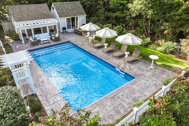 view of pool with an outdoor living space, an outbuilding, and a patio area