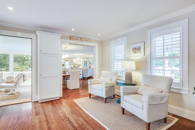 sitting room featuring crown molding and light hardwood / wood-style flooring