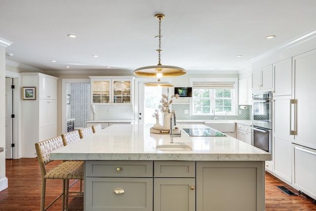 kitchen featuring black electric stovetop, white cabinets, a kitchen island with sink, and gray cabinets