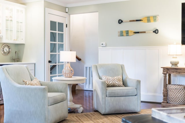 living area featuring hardwood / wood-style floors and crown molding