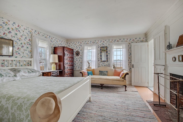 495 Chequessett Neck Rd, Wellfleet, MA 02667 - bedroom featuring wallpapered walls, light wood finished floors, a fireplace with flush hearth, and crown molding