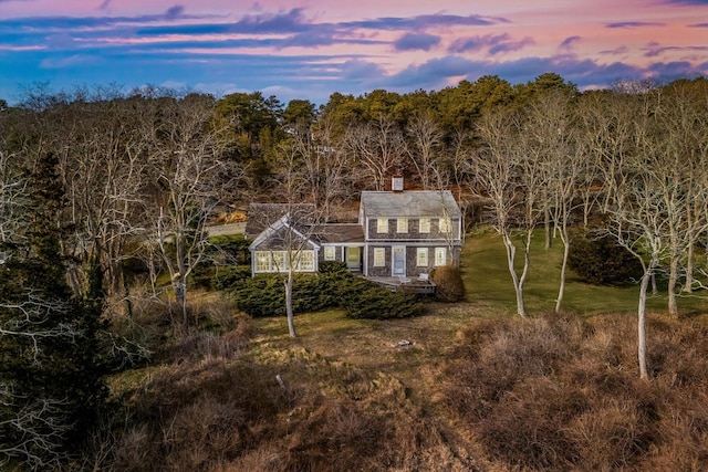 495 Chequessett Neck Rd, Wellfleet, MA 02667 - back of property at dusk featuring a chimney and a yard