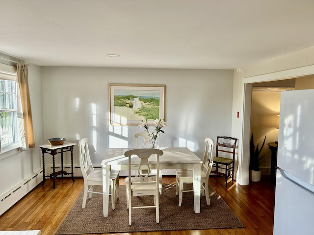 dining room featuring dark wood-type flooring and a baseboard heating unit