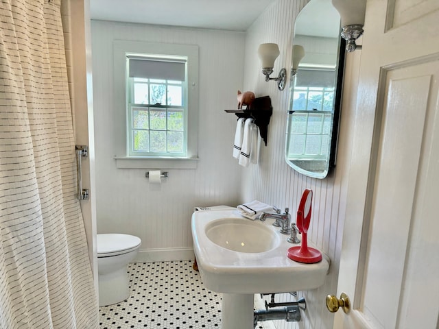 bathroom featuring toilet, a shower with shower curtain, and tile patterned flooring