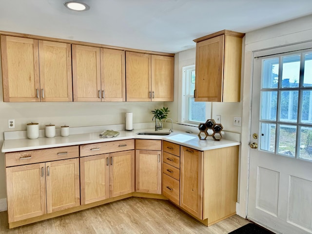 kitchen with sink, light brown cabinets, and light wood-type flooring