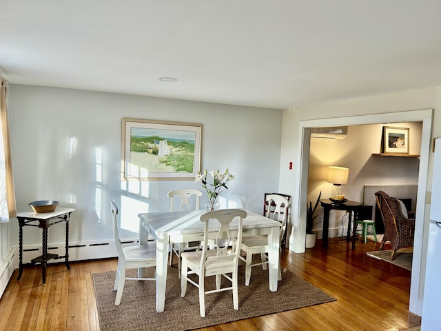 dining area with hardwood / wood-style floors and a wall unit AC