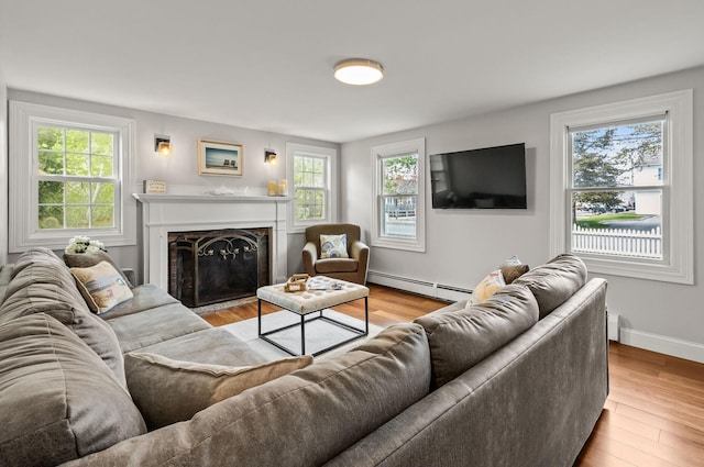 77 Center St, Dennis Port, MA 02639 - living room featuring a baseboard heating unit, healthy amount of natural light, and wood finished floors