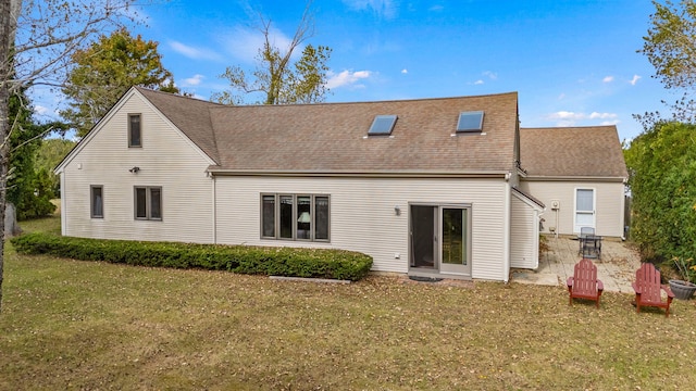 rear view of property featuring roof with shingles and a lawn