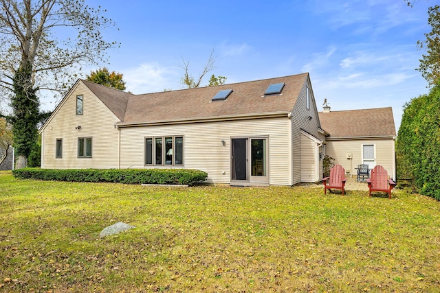 rear view of house with a lawn and roof with shingles