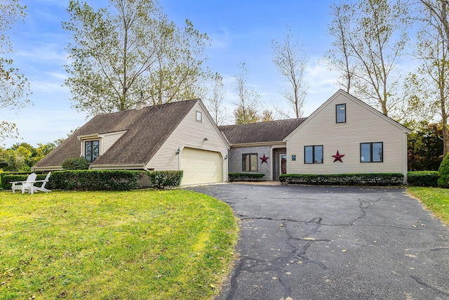 view of front of property with aphalt driveway, a front lawn, and a garage