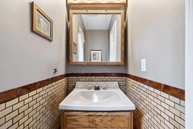 bathroom featuring a wainscoted wall, tile walls, and vanity