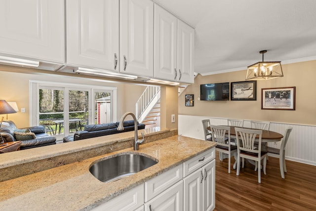 kitchen featuring a sink, white cabinets, ornamental molding, and dark wood finished floors