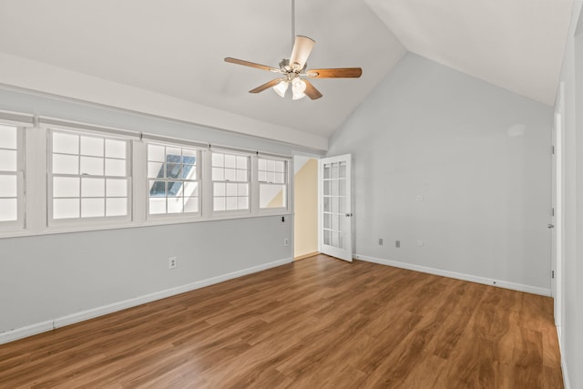 empty room with wood finished floors, baseboards, ceiling fan, and lofted ceiling