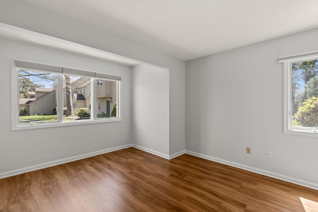 unfurnished room featuring baseboards and wood finished floors
