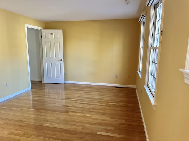 unfurnished room with baseboards, visible vents, and light wood finished floors