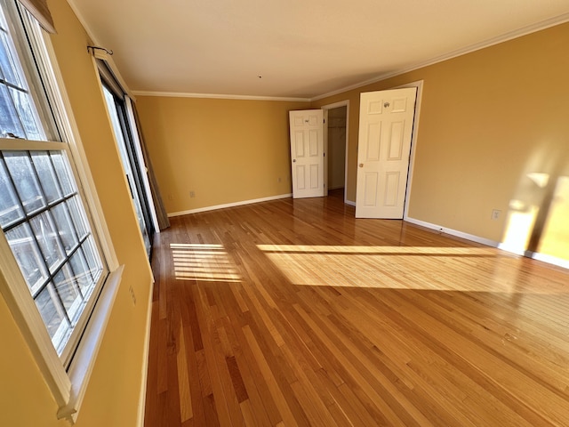 unfurnished bedroom with baseboards, ornamental molding, and wood finished floors