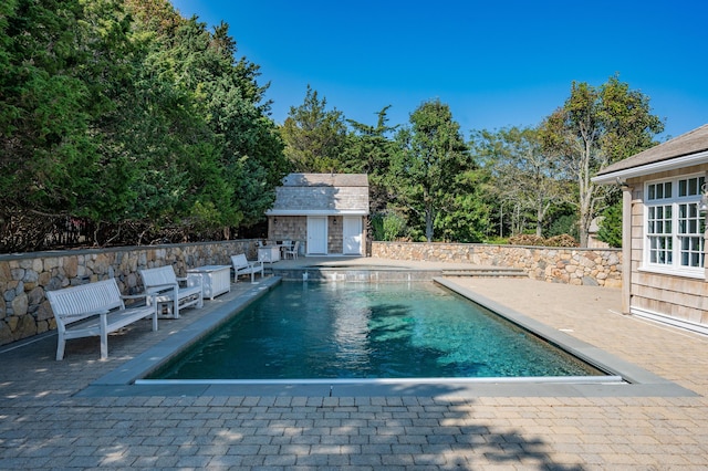 view of pool with a patio and an outdoor structure