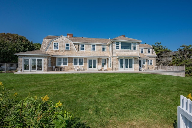 back of property featuring a lawn, french doors, and a patio