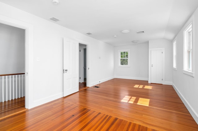 empty room featuring vaulted ceiling and wood-type flooring