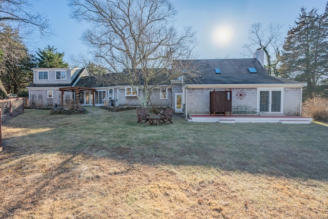 rear view of house with a patio and a lawn