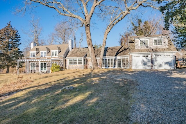 view of front of property featuring a garage, a front lawn, and a pergola