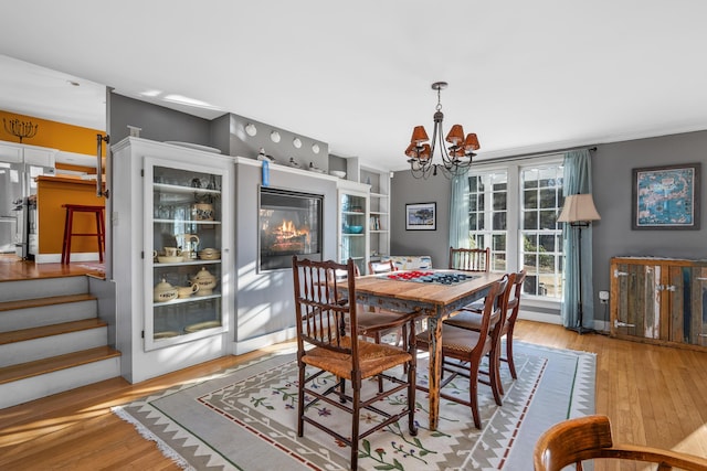 dining area with a notable chandelier and light hardwood / wood-style floors