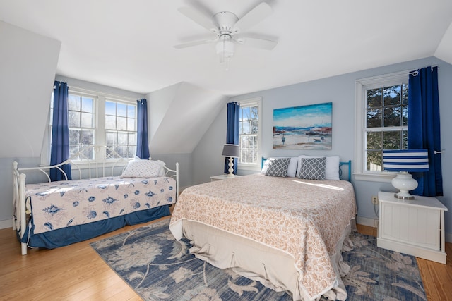 bedroom with ceiling fan, wood-type flooring, and vaulted ceiling