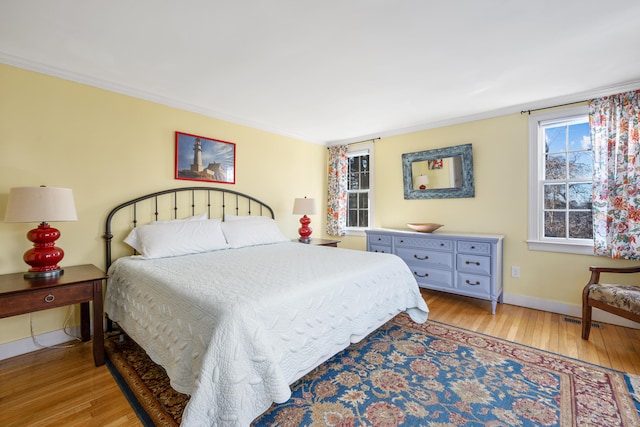 bedroom with ornamental molding and light hardwood / wood-style flooring