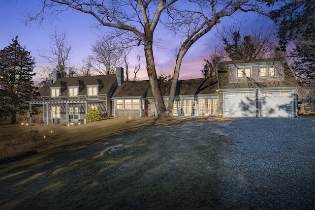 view of front facade featuring a garage and a pergola