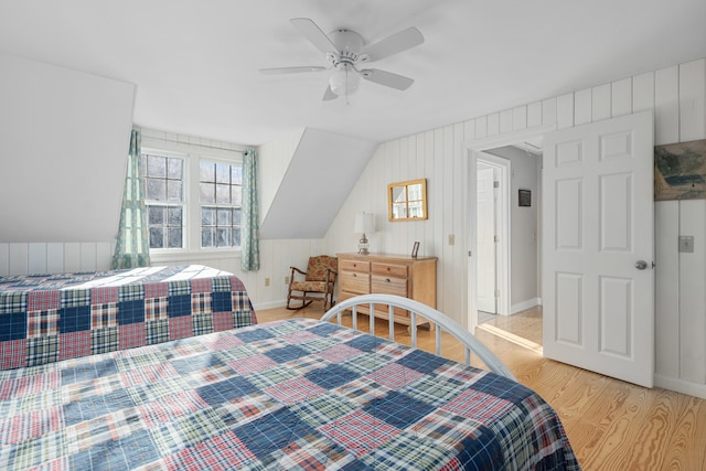 bedroom with ceiling fan, lofted ceiling, and light hardwood / wood-style floors