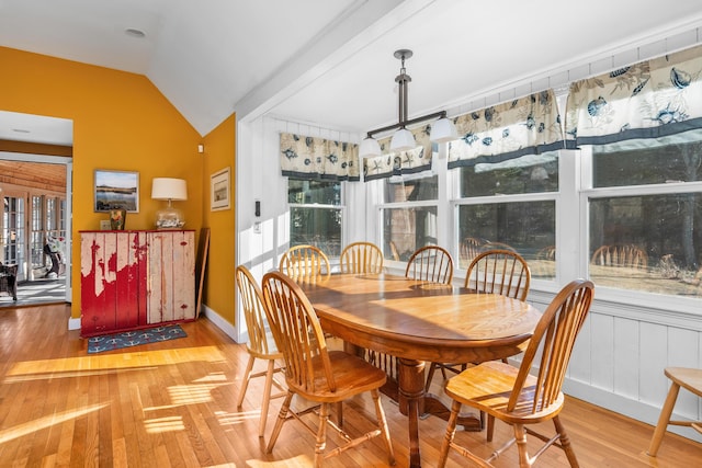 dining space featuring vaulted ceiling and wood-type flooring