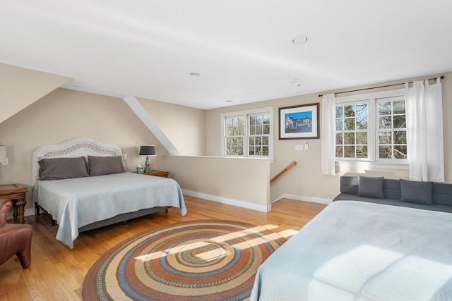 bedroom with multiple windows and light wood-type flooring