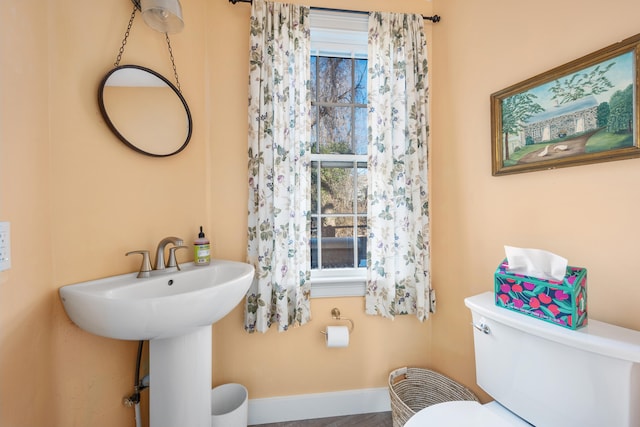 bathroom featuring plenty of natural light, toilet, and sink