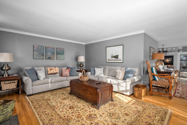 living room with crown molding, hardwood / wood-style floors, and an inviting chandelier