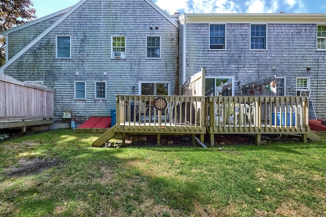 rear view of house featuring a wooden deck and a yard