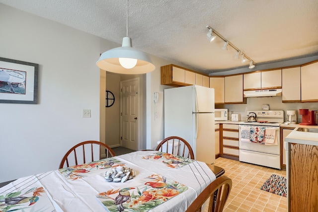 kitchen with sink, a textured ceiling, pendant lighting, white appliances, and cream cabinetry