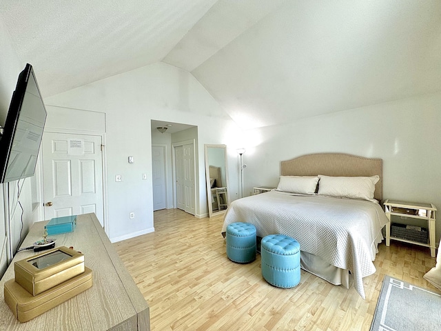 bedroom with light hardwood / wood-style flooring and lofted ceiling