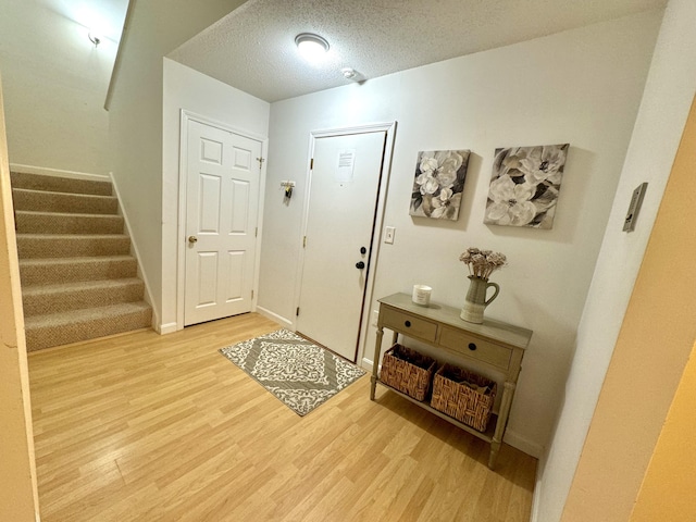 entrance foyer with a textured ceiling and light wood-type flooring