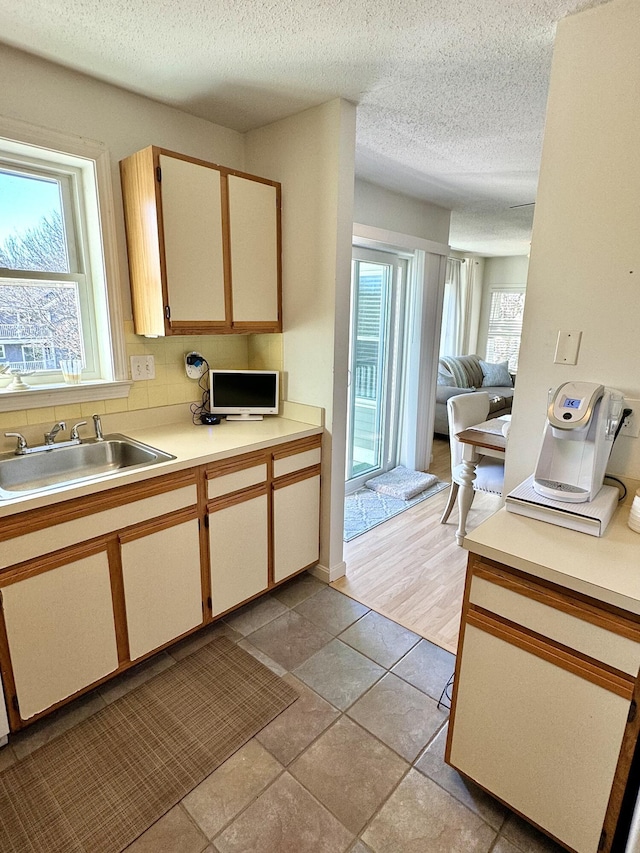 kitchen with sink, a textured ceiling, and light tile patterned floors