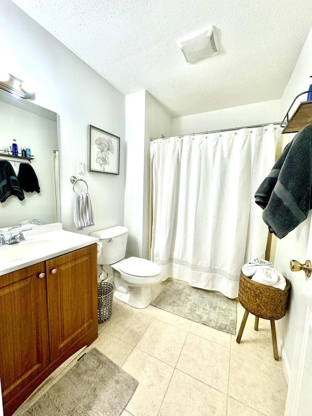 bathroom featuring tile patterned flooring, toilet, a textured ceiling, walk in shower, and vanity