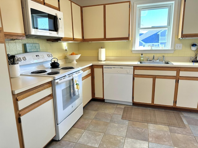 kitchen featuring sink, backsplash, white appliances, and white cabinets