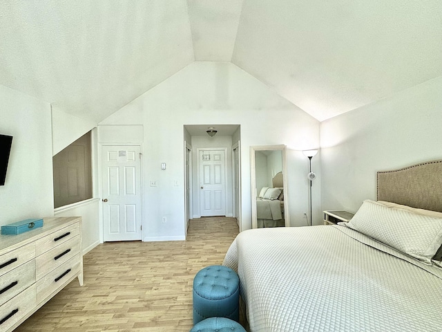 bedroom with light wood-type flooring and lofted ceiling