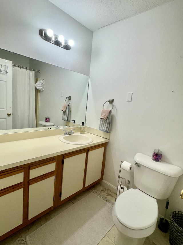 bathroom featuring a textured ceiling, toilet, vanity, and tile patterned flooring