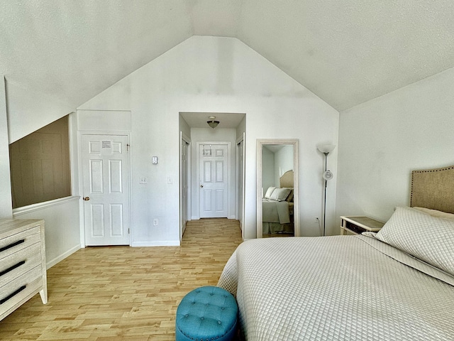 bedroom with light wood-type flooring and lofted ceiling