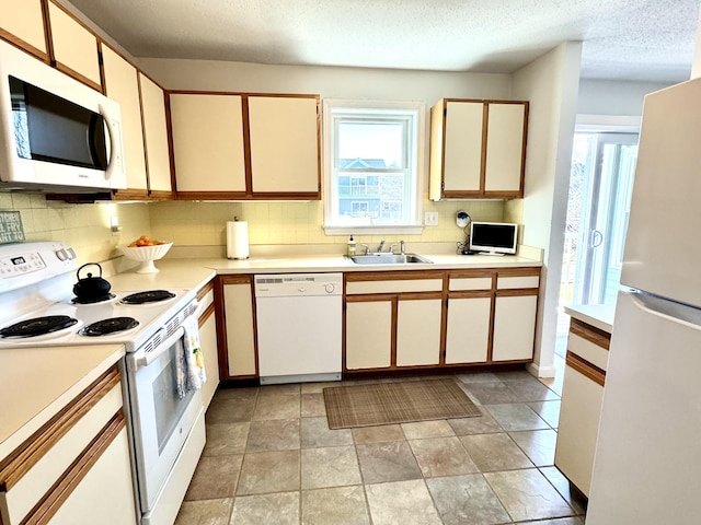 kitchen with sink, white cabinetry, white appliances, and a textured ceiling