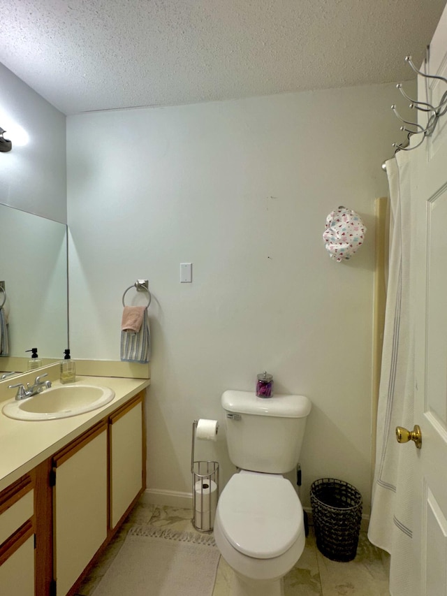 bathroom with a textured ceiling, tile patterned floors, vanity, and toilet