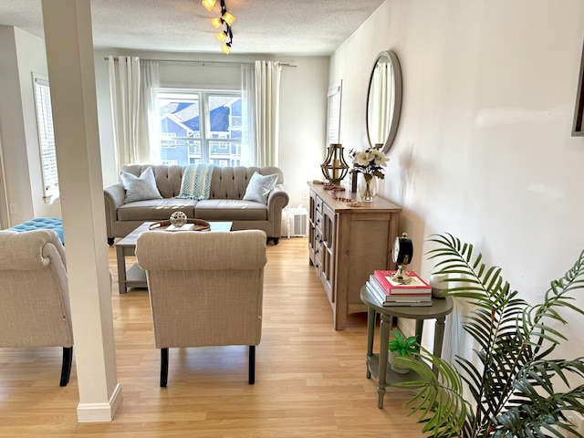 living area featuring a textured ceiling, light hardwood / wood-style flooring, and track lighting