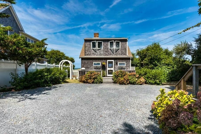 232 Robbins Hill Rd, Brewster, MA 02631 - view of front of house with fence, driveway, and a chimney