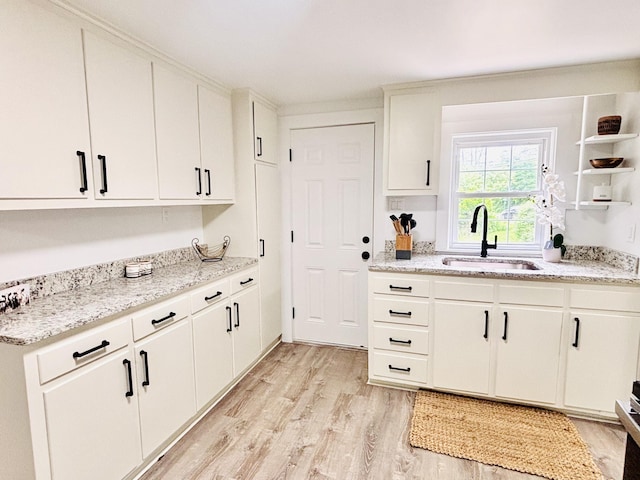 379 Main St, Mashpee, MA 02649 - kitchen with a sink, light wood-type flooring, white cabinets, and light stone counters