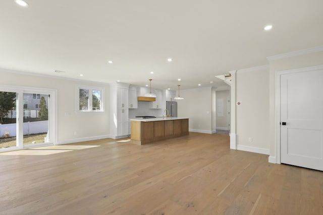 63 Ovington Dr, East Falmouth, MA 02536 - kitchen featuring an island with sink, high quality fridge, light wood finished floors, open floor plan, and ornamental molding
